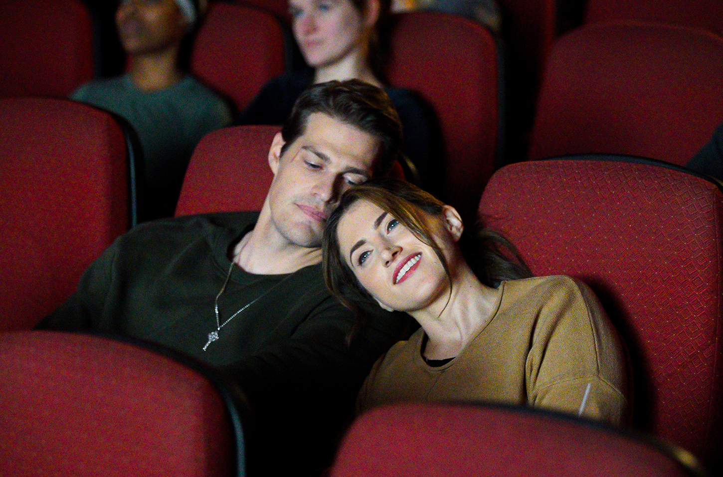 Vrouw legt haar hoofd op de schouder van een man in de bioscoopzaal