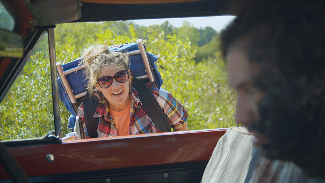 Vrouwlijke backpacker kijkt in een auto voor een rit