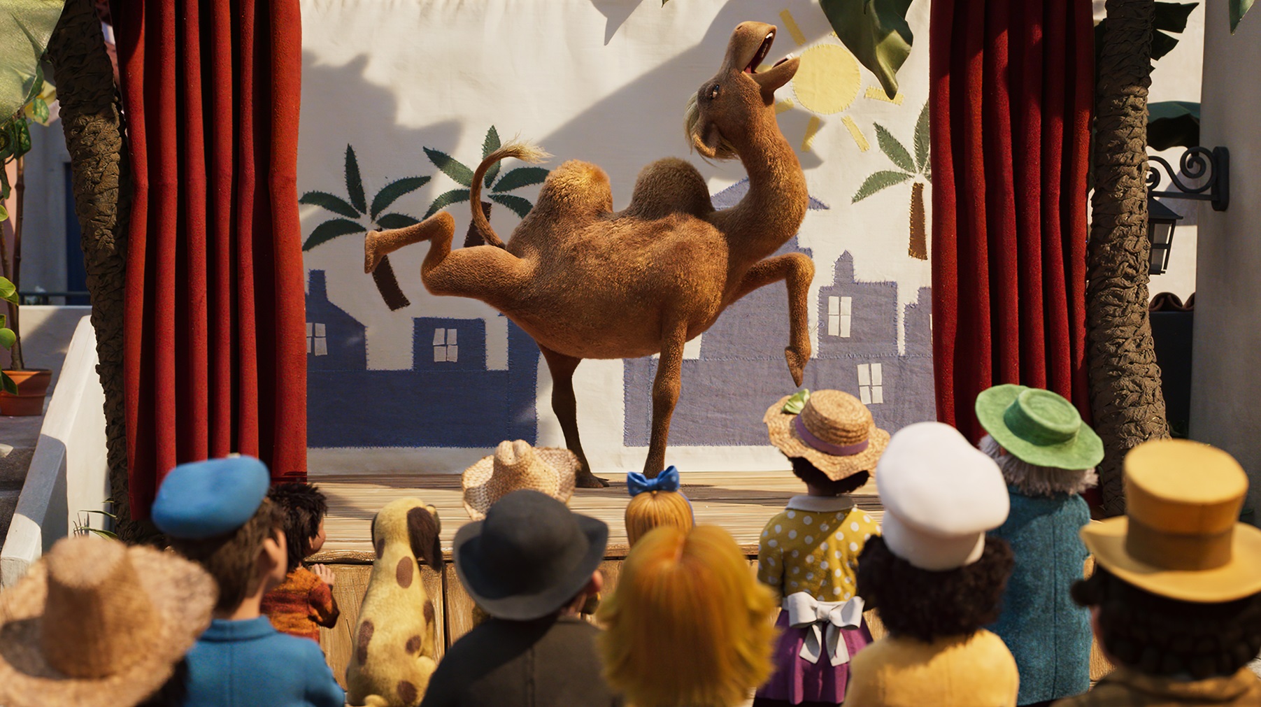 Een kameel doet een optreden op een podium en er zitten veel mensen in het publiek